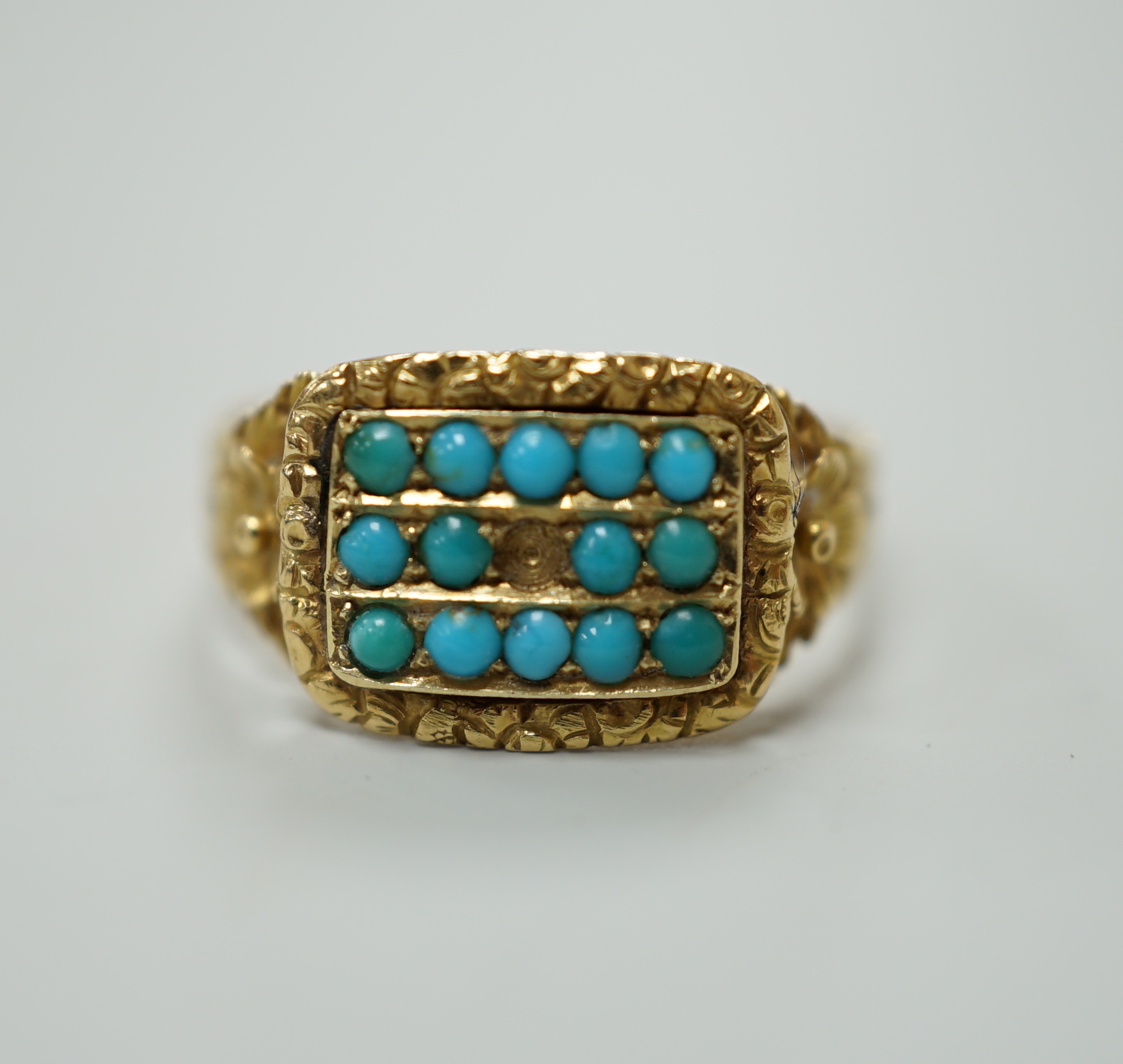 A Victorian gold dress ring, set with three rows of small turquoise flanked by floral carved shoulders, lacks one stone, size O, gross 2.5 grams